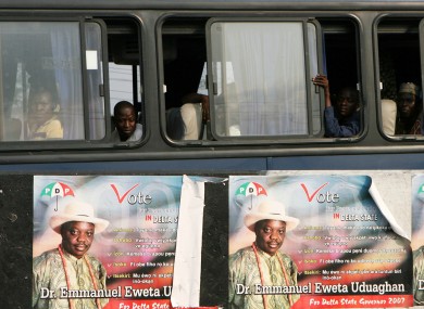 Commuters peer from a bus showing campaign posters of Dr Emmanuel Eweta Uduaghan a candidate for state governor in Port Harcourt Nigeria,