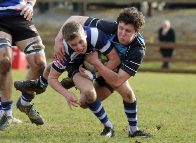 Gary Fitzgerald of Crescent College tackled by John Fox of Castletroy.