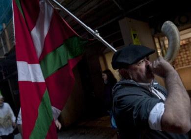 A man dressed in traditional local clothes carries a Basque flag and plays a horn as he takes part in a pro-independence Basque march calling for release of all Basque prisoners of the Basque armed group ETA.