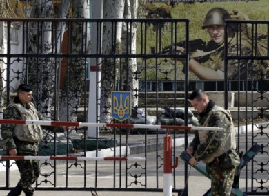 Ukrainian soldiers stand guard at the gate of a military base in the port of Kerch in Crimea.