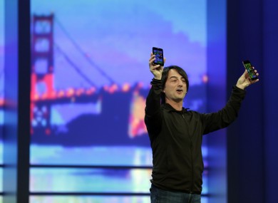 Microsoft corporate vice president Joe Belfiore, holds up new phones using the new Windows 8.1 during the keynote address of the Build Conference.