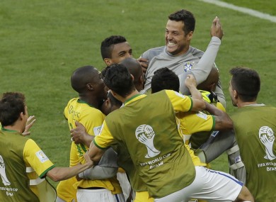 Brazil's goalkeeper Julio Cesar is mobbed by team-mates after they win the penalty shootout.