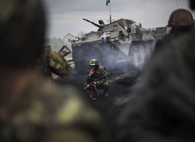 In this May 2 photo, a Ukrainian soldier smokes at a burned-out pro-Russia checkpoint 10km outside the rebel stronghold of Slavyansk.