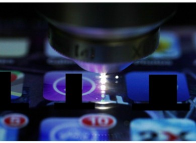 A laser etching a waveguide into the screen.