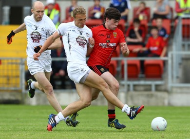 Kildare's Tommy Moolick and Hugh McGrillen with Down's Niall Madine.