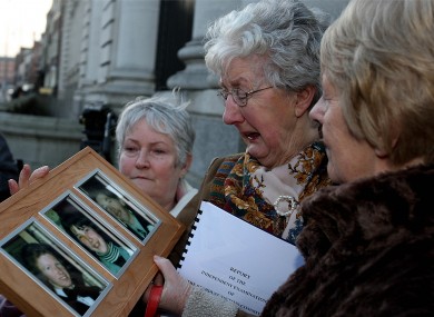 Bride McDermot (centre) holds a picture of her children George,Marcella and William