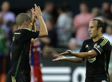 Landon Donovan celebrates scoring with Osvaldo Alonso.