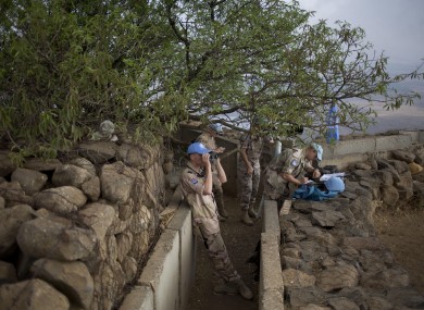 U.N. peacekeepers from the United Nations Disengagement Observer Force, also known as UNDOF, observe Syria's Quneitra province at an observation point on Mt. Bental in the Israeli-controlled Golan Heights.