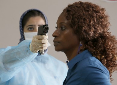 A Moroccan health worker uses a thermometer to screen a passenger at the arrivals hall of the Mohammed V airport in Casablanca.