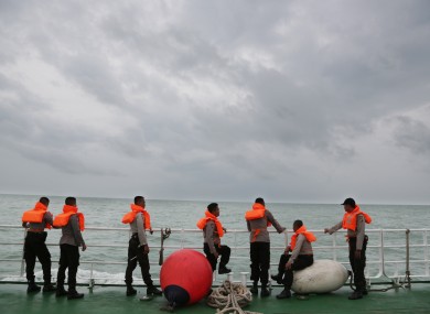 Indonesian police stand on the deck of a National Search And Rescue Agency ship earlier this month.