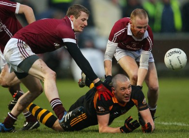 Kieran Donaghy releases the ball under pressure from Slaughtneil defenders.