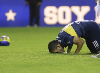 Carlos Tevez kisses the grass of the Bombonera stadium.