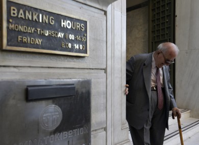 An elderly man leaves a branch of the National Bank of Greece in Athens.