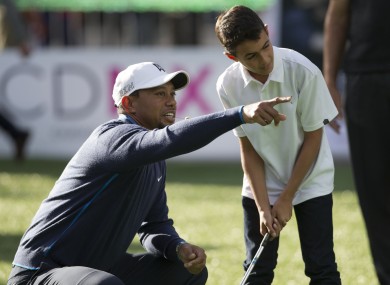 Tiger Woods gives advice to a young golfer earlier this week.