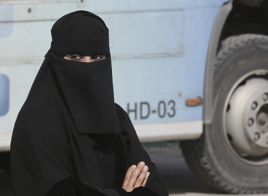 A Saudi woman waits outside a polling centre as she prepares to cast her ballot.