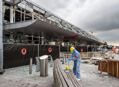 A forensics officer works in front of the damaged Zaventem Airport terminal in Brussels.