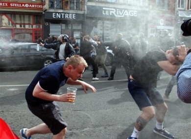 English fans run after getting sprayed with pepper spray by French police during scuffles in downtown Lille, northern France, earlier today.