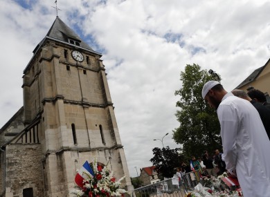 Muslim worshippers hold a minute of silence in front of the memorial at the Saint Etienne church in Saint-Etienne-du-Rouvray, Normandy.