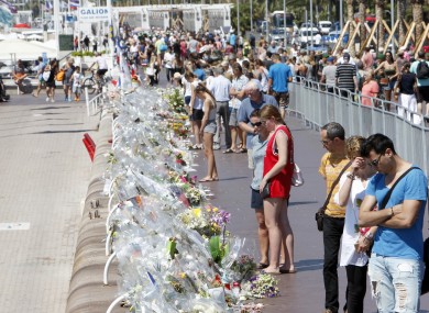People look at flowers at the Promenade des Anglais in Nice.