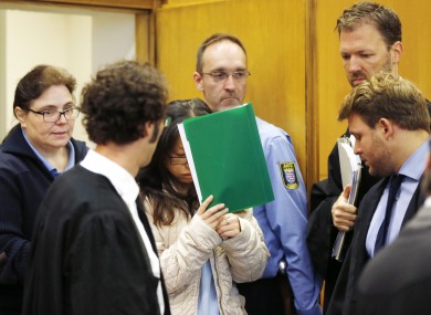 One of the accused covers her face entering a court in Frankfurt.