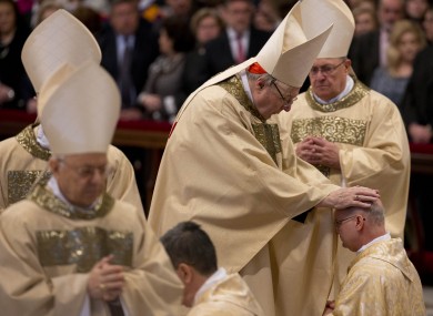 Cardinal George Pell poses his hands on the head of a newly ordained bishop.
