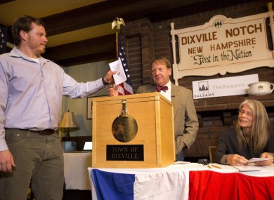 Dixville Notche's first voter Clay Smith drops his ballot into the box as moderator Tom Tillotson watches.