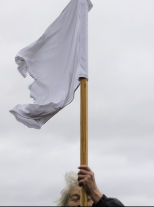 A demonstrator holds a white flag as she attends the Civil March for Aleppo at the airfield of the former airport Tempelhof in Berlin last Monday.