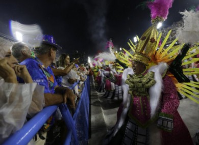 A performer from the Paraiso do Tuiuti samba school greets spectators during Carnival celebrations.