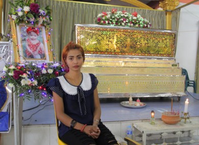 Chiranut Trairat sits in front of her daughter's coffin at Si Sunthon temple in Phuket, Thailand
