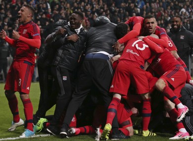 Lyon players celebrate at the end of a penalty shootout during a Europa League quarter-final.