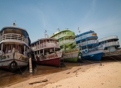Five boats moored on the banks of the Amazon river in Brazil.