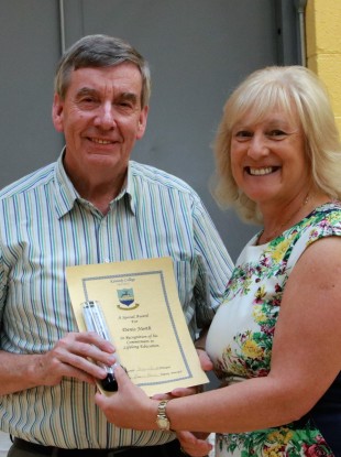 Denis North receiving an achievement award for lifelong learning from principal Suzanne Barrett at Kennedy College