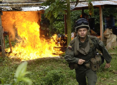 A Colombian anti-narcotic police officer destroys a cocaine laboratory in Tolima, Colombia.