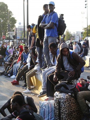 Migrants waiting to be removed from aid centre in Paris.