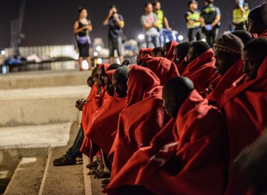52 migrants, among them a woman and two boys, huddle on shore after being rescued by the Spanish Maritime last month.