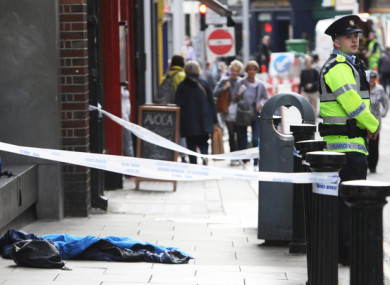 A Garda stands near the scene where the homeless man was discovered unconscious early this morning.