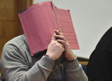 Niels Hoegel hides his face during a court hearing in 2015.
