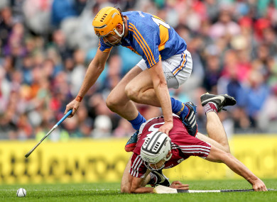 Seamus Callanan and Daithi Burke battle for possession.