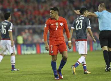 Chile's Alexis Sanchez, centre, walks on the field during a 2018 World Cup qualifying soccer match against Paraguay.