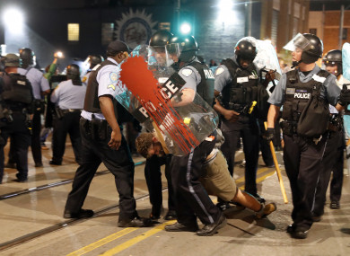 Police arrest a man as they try to clear a violent crowd.