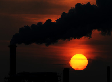 File photo of the sun setting behind a smoking chimney of an industrial plant in Wismar.