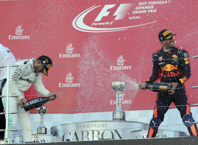 Hamilton sprays champagne at third placed Red Bull driver Daniel Ricciardo.