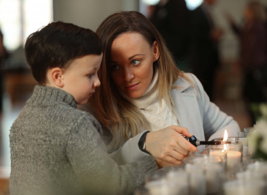 Lisa Marie Maher and her son Harry Foy (5) light a candle in remembrance of Harry's grandfather Eugene Maher.