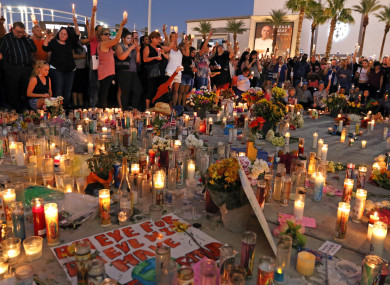 People attend a candlelight vigil on the corner of Las Vegas Boulevard and Sahara Avenue