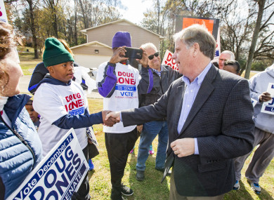 Democratic Senatorial candidate Doug Jones greets supporters as he campaigns outside the polls earlier today.
