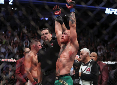 John McCarthy raises Conor McGregor's hand after his victory in the rematch with Nate Diaz at UFC 202.
