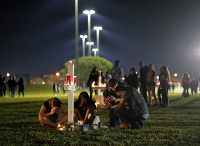People sitting during a candlelit vigil for the victims of the shooting.