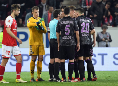 Freiburg players argue with the referee.