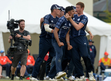Safyaan Sharif is mobbed by his team mates after taking the final wicket of the game.