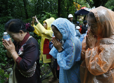 Relatives pray for the return of their loved ones near the site.